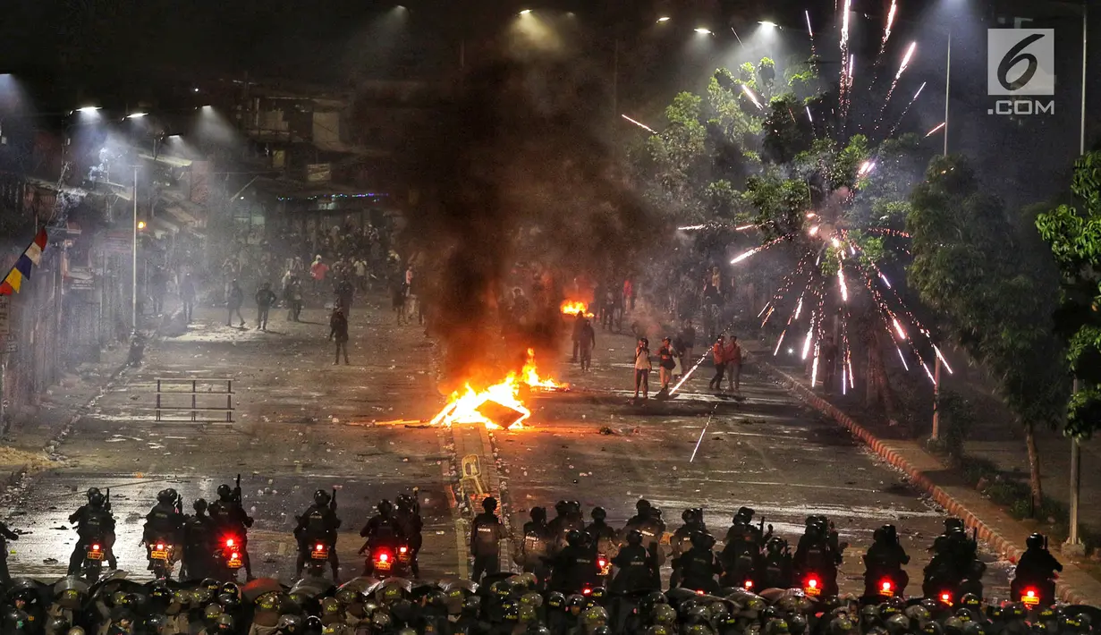 Polisi menembakan petasan dan gas air mata ke kerumunan massa di kawasan Pejompongan, Jakarta, Senin (30/9/2019). Demonstrasi menolak UU KPK hasil revisi dan RUU KUHP di depan Gedung DPR/MPR berakhir ricuh. (Liputan6.com/JohanTallo)