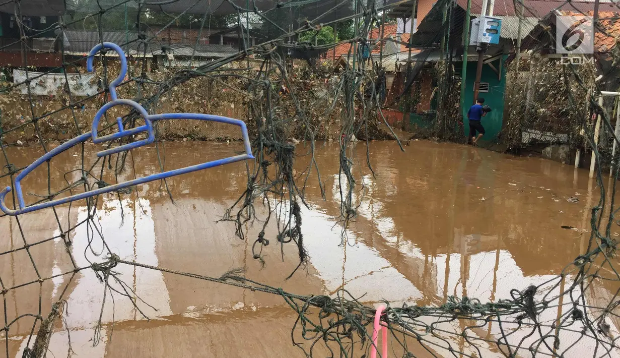 Sampah dan lumpur terlihat di lapangan futsal di kawasan Rawajati, Jakarta, Selasa (6/2). Banjir yang merendam kawasan tersebut menyebabkan lumpur dan sampah mengendap di setiap sudut sehingga mengganggu aktivitas warga. (Liputan6.com/Immanuel Antonius)