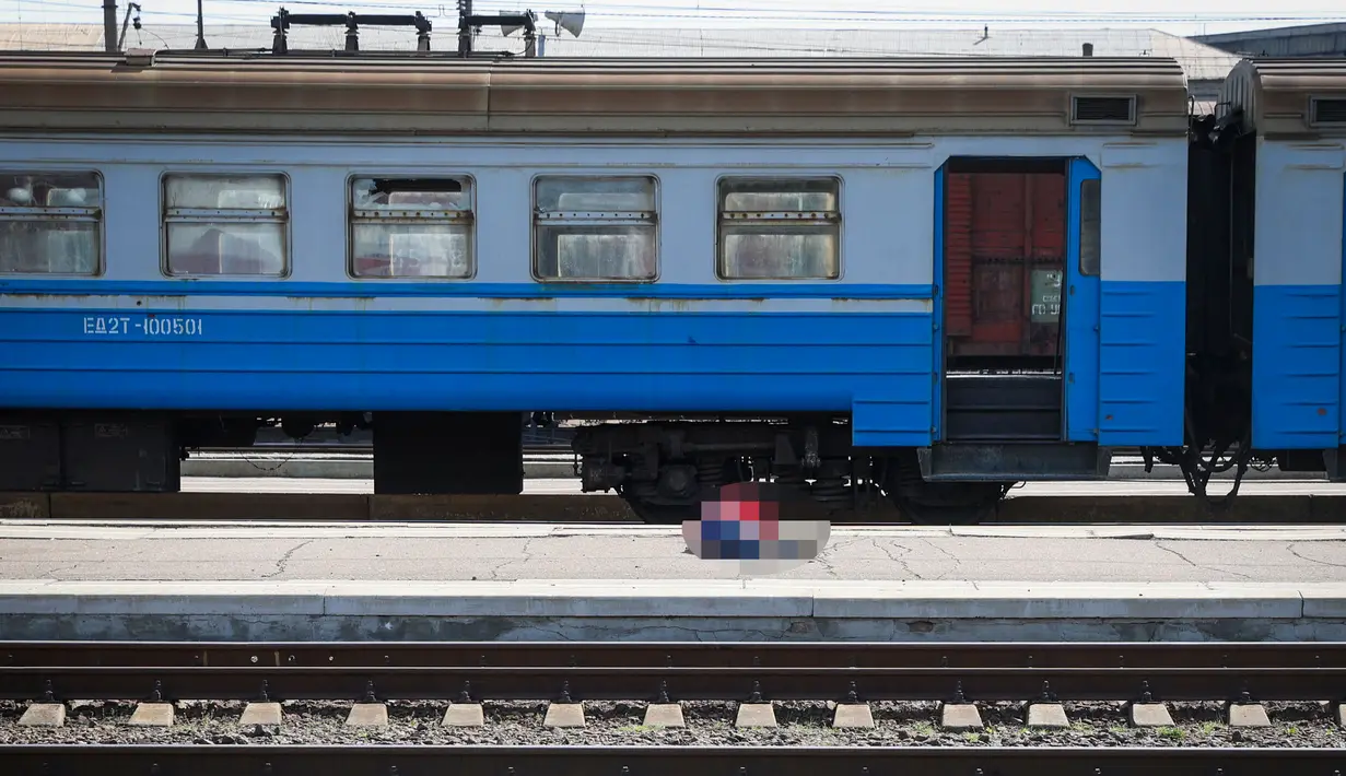 Seorang korban tergeletak di peron setelah serangan roket di stasiun kereta api di kota timur Kramatorsk, di wilayah Donbass (8/4/2022). Sekitar 50 orang tewas dan lebih dari 100 terluka dalam serangan roket di stasiun kereta api kata kepala perusahaan kereta api. (AFP/Anatolii Stepanov)