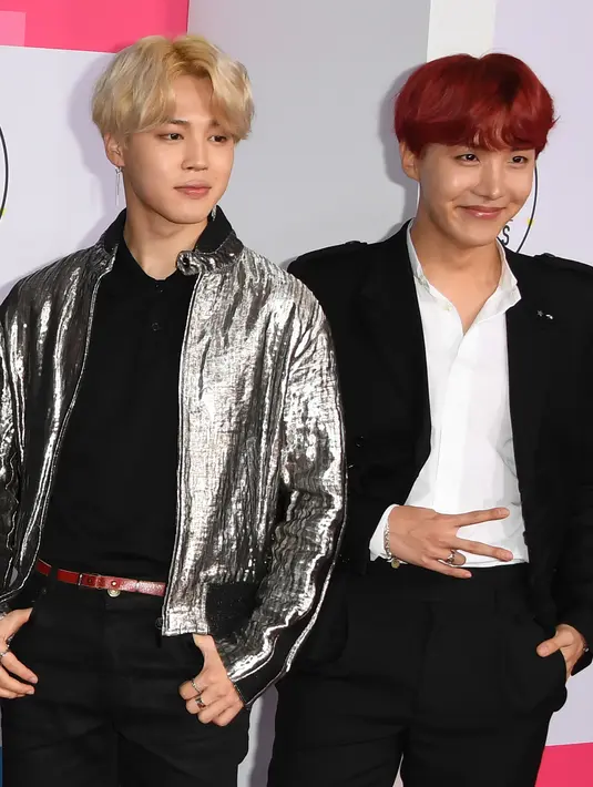 Personel boyband Bangtan Boys alias BTS, Jimin dan J-Hope di karpet merah ajang American Music Awards 2017 di Los Angeles, Minggu (19/11). Jimin mencuri perhatian dengan jaket warna silver dan J-Hope tampil keren dengan rambut merahnya. (Mark Ralston/AFP)