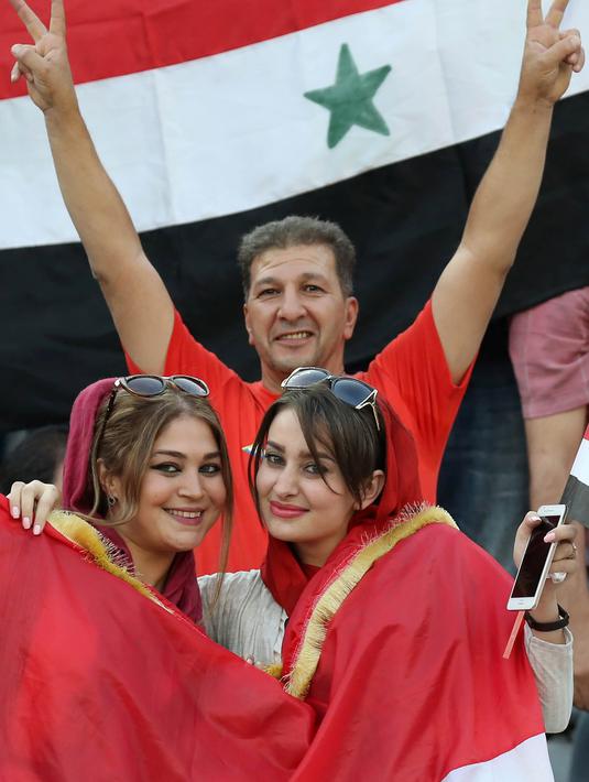 Suporter Suriah memberi dukungan saat laga kualifikasi Piala Dunia 2018 melawan Iran di Stadion Azadi, Tehran, Selasa (5/9/2017). Finis urutan tiga grup A, Suriah lolos ke babak playoff untuk menantang Australia. (AFP/Atta Kenare)