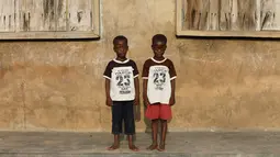 Si kembar identik, Taiwo Ahmed dan Kehinde Ahmed berpose di Igbo Ora, Negara Bagian Oyo, Nigeria pada 4 April 2019. Sebuah studi tahun 1970-an yang dilakukan oleh ilmuan Inggris menemukan bahwa sekitar 50 pasang anak kembar lahir dari setiap 1.000 kelahiran di Igbo Ora. (REUTERS/Afolabi Sotunde)