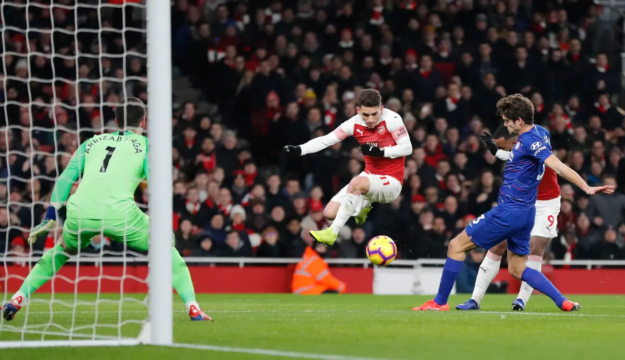 Striker Arsenal, Alexandre Lacazette berusaha memasukan bola dari kawalan bek Chelsea Marcos Alonso selama pertandingan lanjutan Liga Inggris di stadion Emirates di London (19/1). Arsenal menang 2-0 atas Chelsea. (AP Photo/Frank Augstein)