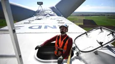 Seorang operator teknis mengamati dari sebuah palka di atap ruang mesin yang terletak di bagian atas turbin angin saat kegiatan pemeliharaan di Andilly-les-Marais dekat La Rochelle, Prancis barat pada tanggal 10 Maret 2025. (Christophe ARCHAMBAULT/AFP)