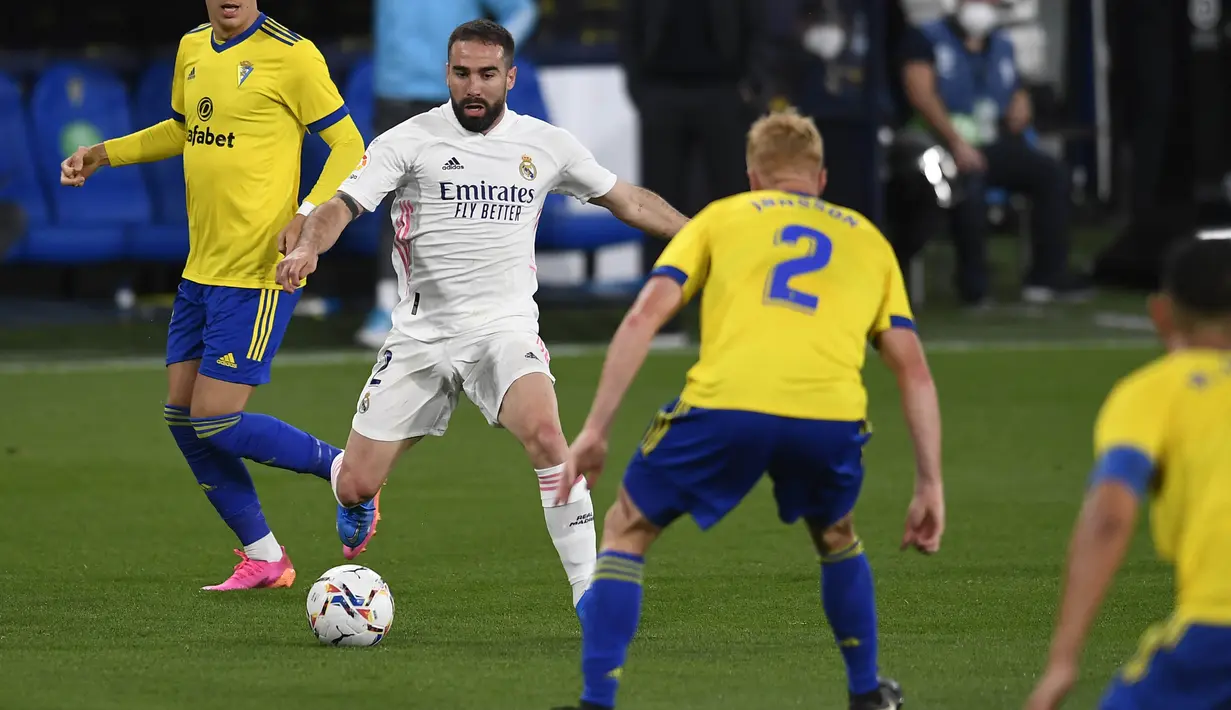 Bek Real Madrid, Dani Carvajal, berusaha melewati pemain Cadiz pada laga Liga Spanyol di Stadion Ramon de Carranza, Rabu (22/4/2021). Real Madrid menang dengan skor 3-0. (AP Photo/Jose Breton)