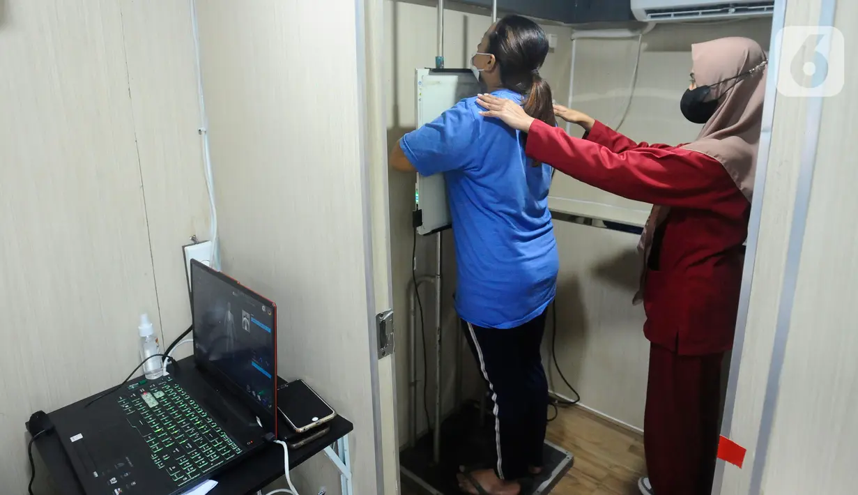Warga melakukan ronsen pada mobile  X-Ray Artificial Intelligence saat kegiatan skrining penyakit tuberkulosis (TBC) di Kantor Kecamatan Cipayung, Depok, Jawa Barat, Rabu (4/1/2023). Kementerian Kesehatan (Kemenkes) RI melakukan skrining besar-besaran untuk menemukan 500 ribuan orang yang belum diobati dan berisiko menjadi sumber penularan penyakit TBC. (merdeka.com/Arie Basuki)