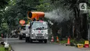 Petugas Palang Merah Indonesia (PMI) menyemprotkan disinfektan menggunakan armada Gunner Spray di kawasan Blok M, Jakarta, Minggu (12/4/2020). Penyemprotan dilakukan untuk mencegah penyebaran virus corona COVID-19. (Liputan6.com/Faizal Fanani)