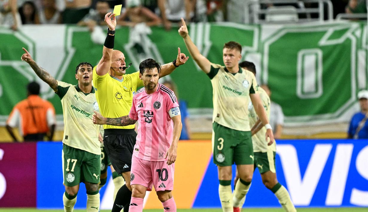 Pemain Inter Miami, Lionel Messi mendapatkan kartu kuning dari wasit setelah melakukan pelanggarang dengan pemain Palmeiras dalam laga Grup A Piala Dunia Antarklub 2025 di Hard Rock stadium, Miami, Amerika Serikat, Selasa (24/06/2025) WIB. (AFP/Patricia De Melo Moreira)