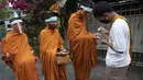 Warga memberikan gel alkohol kepada para biksu Buddha yang memakai pelindung wajah untuk melindungi diri dari virus corona COVID-19 saat mengumpulkan sedekah di Bangkok, Thailand, Selasa (31/3/2020). Hingga 30 Maret 2020 sore, kasus positif COVID-19 di Thailand ada 1.524. (AP Photo/Sakchai Lalit)