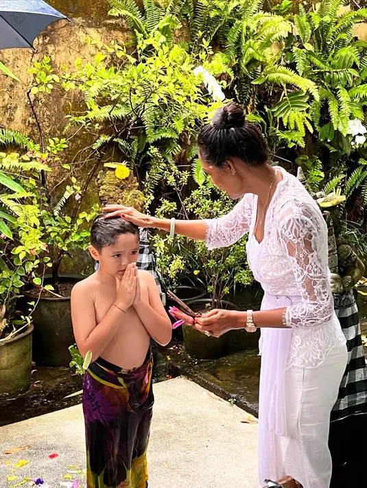 El terlihat mengenakan kemeja putih yang dipadukan dengan kain tenun panjang dengan warna dasar hitam yang disebut sebagai kamben. Tidak ketinggalan, El juga mengenakan udeng putih di atas kepalanya. [instagram/inijedar]