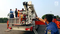 Petugas pemadam kebakaran bersiap mengantar pengunjung menaiki Bronto Skylift di Monas, Jakarta, Minggu (23/11). Dengan naik Bronto Skylift pengunjung bisa melihat Monas dari dekat. (Liputan6.com/JohanTallo)