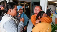Anggota keluarga dan kerabat menunggu kabar terbaru tentang operasi pencarian sebuah kapal feri yang tenggelam di lepas pantai Bali, di Pelabuhan Ketapang, Banyuwangi, Jawa Timur, pada Kamis 3 Juli 2025. (Foto oleh AFP)