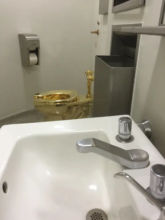 Kloset berlapis emas 18 karat yang dipasang di salah satu toilet di Museum Guggeinheim, New York, Kamis (15/9). Kloset mewah itu untuk menggantikan salah satu kloset porselen di toilet umum yang terbuka bagi semua jenis kelamin. (William EDWARDS/AFP)