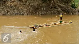 Tim penyisir Ciliwung menggunakan perahu getek saat membersihkan sampah yang menggenang di jalur kali Ciliwung Codet saat perayaan Hari Ciliwung 2015, Jakarta Timur, Rabu (11/11/2015). (Liputan6.com/Yoppy Renato)