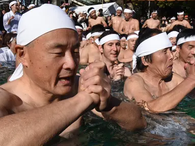 Penganut Shinto berdoa di kolam renang es untuk memurnikan tubuh dan jiwa dalam ritual Upacara Penyucian di Tokyo, Minggu (10/01/2016). (AFP Photo/ Toru Yamanaka)