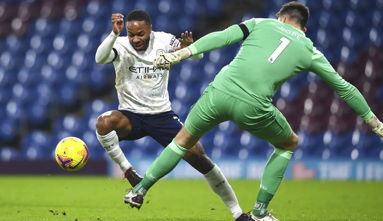 Pemain Manchester City Raheem Sterling (kiri) berhadapan dengan penjaga gawang Burnley Nick Pope pada pertandingan Liga Inggris di Stadion Turf Moor, Burnley, Inggris, Rabu (3/2/2021). Manchester City menang 2-0. (Gareth Copley/Pool via AP)