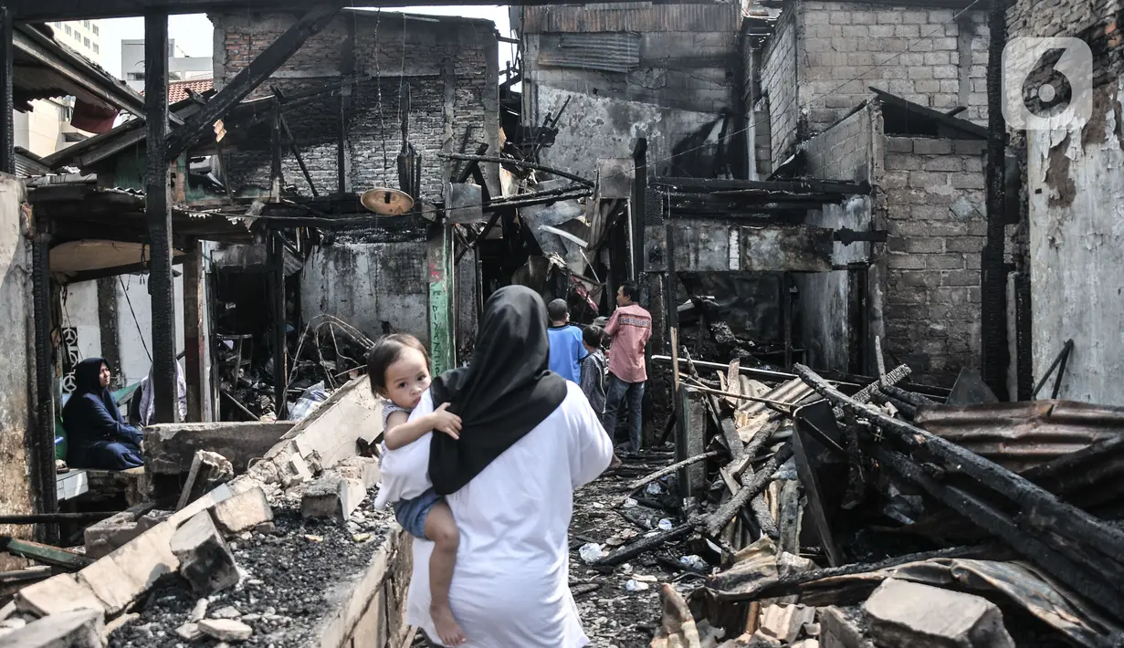 Warga menyaksikan kondisi rumah pasca kebakaran melanda permukiman padat penduduk di Jalan Cikini Kramat, RT 004 dan 015, RW 001, Kelurahan Pegangsaan, Kecamatan Menteng, Jakarta Pusat, Selasa (27/9/2022). Kebakaran yang terjadi sekitar pukul 04.35 tadi diduga berasal dari ledakan kompor gas pedagang bubur yang menyebabkan satu orang mengalami luka bakar dan puluhan rumah yang dihuni 75 kepala kepala keluarga ludes dilalap api. (merdeka.com/Iqbal S Nugroho)
