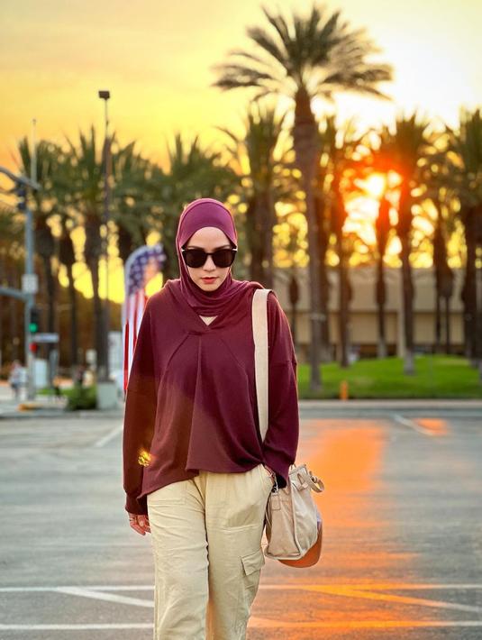 Mengenakan atasan oversized jerau tanpa motif plus jilbab berwarna senada yang dipadukan dengan celana panjang kapisa, Zaskia Adya Mecca berpose di jalanan. Latar sejumlah pohon yang menghalangi cahaya matahari plus bendera AS yang berkibar membuat gayanya tak kalah dari model papan atas. Kacamata hitam menyempurnakan penampilannya. (Foto: Dok. Instagram @zaskiadyamecca)