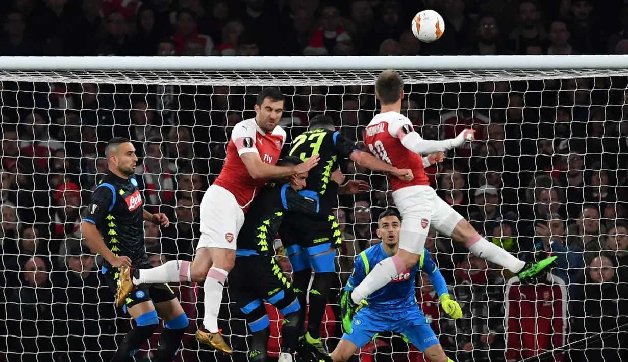 Duel udara terjadi pada laga Arsenal vs Napoli pada leg 1, babak perempat final Liga Europa yang berlangsung di Stadion Emirates, London, Jumat (12/4). Arsenal menang 2-0 atas Napoli. (AFP/Ben Stansall)