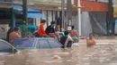 Keadaan darurat dan peringatan baru untuk hujan lebat dan banjir bandang telah dikeluarkan oleh Departemen Meteorologi Thailand. Tampak dalam foto, orang-orang berkumpul di samping sebuah toko swalayan 7/11 saat banjir tinggi melanda Hat Yai, Provinsi Songkhla, Thailand selatan, pada 26 November 2025. (Arnun Chonmahatrakool/THAI NEWS PIX/AFP)