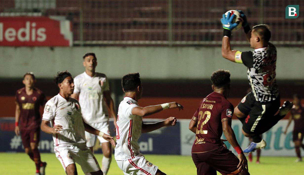 Kiper Persija Jakarta, Andritany Ardhiyasa (kanan) berhasil menangkap bola hasil tendangan pemain PSM Makassar dalam laga leg pertama semifinal Piala Menpora 2021 di Stadion Maguwoharjo, Sleman, Kamis (15/4/2021). Kedua tim bermain imbang 0-0. (Bola.com/Ikhwan Yanuar)
