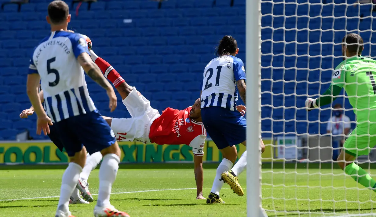 Penyerang Arsenal, Pierre-Emerick Aubameyang (tengah) berusaha melakukan tendangan salto saat melawan Brighton & Hove Albion pada lanjutan pertandingan Liga Inggris di The American Express Community Stadium, Sabtu (20/6/2020). Arsenal tumbang 1-2 di tangan Brighton. (Mike Hewitt/Pool via AP)