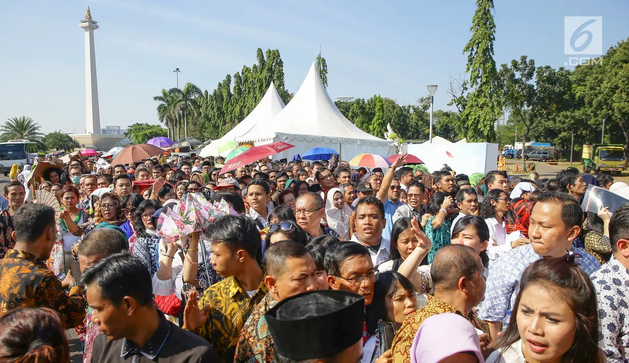 Warga mengantre di kawasan Silang Monas, untuk mengikuti Open House Jokowi di Istana Kepresidenan, Jakarta Rabu (5/6/2019). Warga mulai rela antre setelah Salat Id meski Istana baru dibuka pada pukul 10.00 WIB. (Liputan6.com/HO/Grandy)
