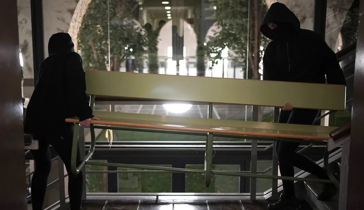 Pendukung rapper Pablo Hasel membuat barikade di dalam Universitas Lleida, Spanyol, Senin (15/2/2021). Pablo Hasel dijatuhi hukuman penjara karena diduga menghina monarki negara dan mendukung terorisme. (AP Photo/Joan Mateu)