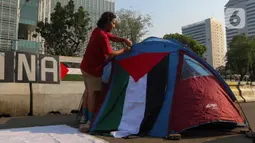 Sejumlah orang yang tergabung dalam Koalisi Musisi untuk Gaza melakukan aksi mendirikan tenda di depan Kedutaan Besar Amerika Serikat, Jakarta, Jumat (10/5/2024). (Liputan6.com/Herman Zakharia)