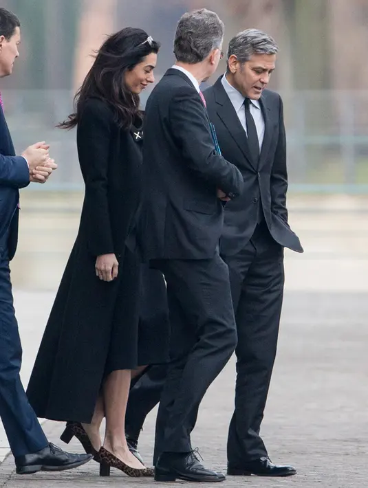 Aktor AS, George Clooney dan istrinya, Amal Alamuddin usai menemui Kanselir Jerman, Angela Merkel (kedua kiri) di Berlin, Jerman, Jumat (12/2). Pertemuan keduanya guna membahas krisis pengungsi di Eropa. (Kay NIETFELD/DPA/AFP)