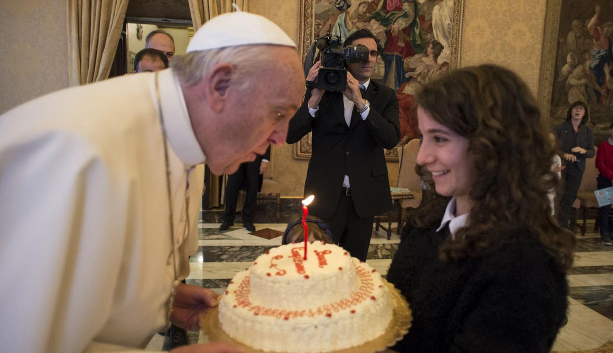 Paus Fransiskus meniup lilin kue ulang tahunnya yang diberikan oleh seorang anggota Italian Catholic Action saat ulang tahun ke-79 tahun di Vatikan, Kamis (17/12/2015). (REUTERS/Osservatore Romano)