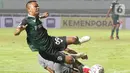 Kapten tim Persikabo 1973, Manahati Lestusen (kir) saat berebut bola dengan pemain Persebaya Surabaya pada lanjutan pekan pertama BRI Liga 1 Indonesia 2022-2023 di Stadion Pakansari, Kabupaten Bogor, Senin (25/7/2022). Persikabo 1973 unggul atas Persebaya Surabaya lewat gol dari titik penalti yang dicetak Gustavo Tocantins. (Liputan6.com/Helmi Fithriansyah)