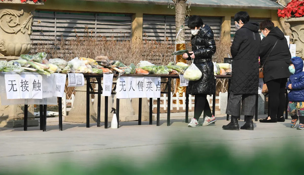 Warga membeli sayuran di kios sayur tak berpenjaga di permukiman di Distrik Xinhua, Shijiazhuang, Provinsi Hebei, China (12/2/2020). Kios sayur tak berpenjaga itu didirikan untuk menyediakan sayuran kepada warga dengan kontak minimal sebagai upaya melawan epidemi virus corona. (Xinhua/Xu Jianyuan)