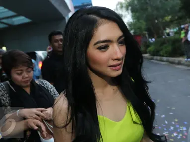 Angel Karamoy bergegas menuju mobil seusai mengisi acara di salah satu stasiun tv, Jakarta, Rabu (30/12). Angel masih tetap bungkam saat di tanyai wartawan tentang permasalahan rumah tangganya. (Liputan6.com/Herman Zakharia)