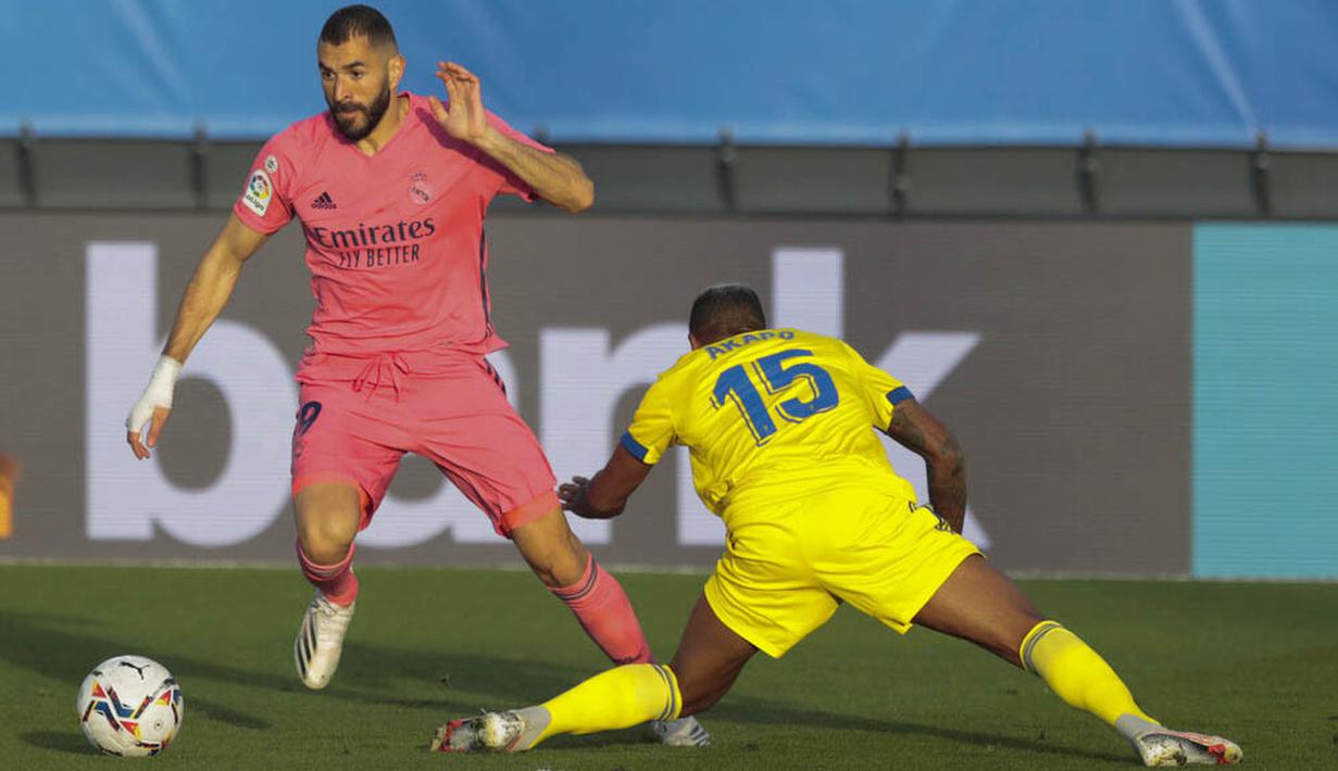 Striker Real Madrid, Karim Benzema, berusaha melewati pemain Cadiz, Carlos Akapo, pada laga Liga Spanyol di Stadion Alfredo Di Stefano, Minggu (18/10/2020). Real Madrid takluk dengan skor 1-0. (AP/Bernat Armangue))muh