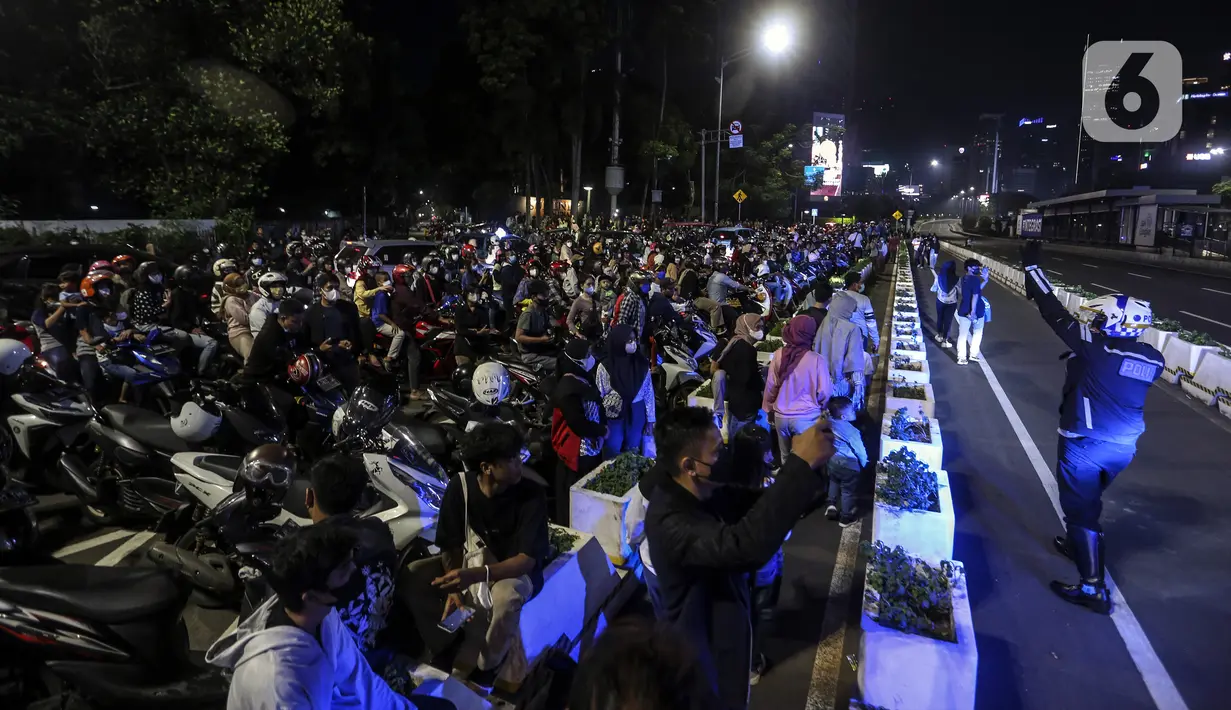 Polisi membubarkan kerumunan warga saat perayaan malam Tahun Baru di Jakarta, Jumat (31/12/2021). Polda Metro Jaya melakukan pengendalian mobilitas Crowd Free Night (malam bebas keramaian) dengan membubarkan warga yang nekat keluar rumah dan tidak mematuhi aturan. (Liputan6.com/Johan Tallo)
