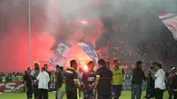 Aremania menyalakan flare merayakan kemenangan Arema Cronus atas Persela Lamongan. (Bola.com/Fahrizal Arnas)