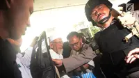Terpidana kasus terorisme, Abu Bakar Baasyir (kiri) dengan pengawalan aparat kepolisian saat tiba untuk menjalani pemeriksaan kesehatan di RSCM, Jakarta, Kamis (1/3). (Merdeka.com/Imam Buhori)