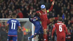 Bek Liverpool, Virgil Van Dijk, duel udara dengan dengan pemain Crvena Zvezda, El Fardou Ben Nabouhane, pada laga Liga Champions, di Stadion Anfield, Rabu (24/10/2018). Liverpool menang 4-0 atas Crvena Zvezda. (AP/Jon Super)