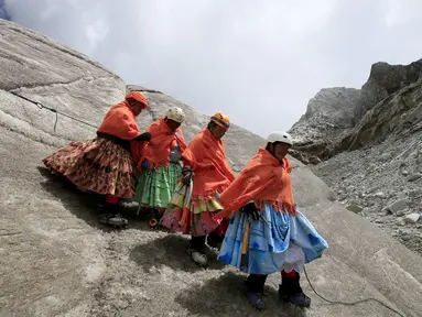 Perempuan suku Aymara mendaki Gunung Huayna Potosi, Bolivia (6/4). Sebanyak 12 perempuan Suku Aymara rata-rata berusia 42-50 tahun ini berhasil menaklukkan puncak Gunung Huayna Potosi dan Illimani. (REUTERS/David Mercado)