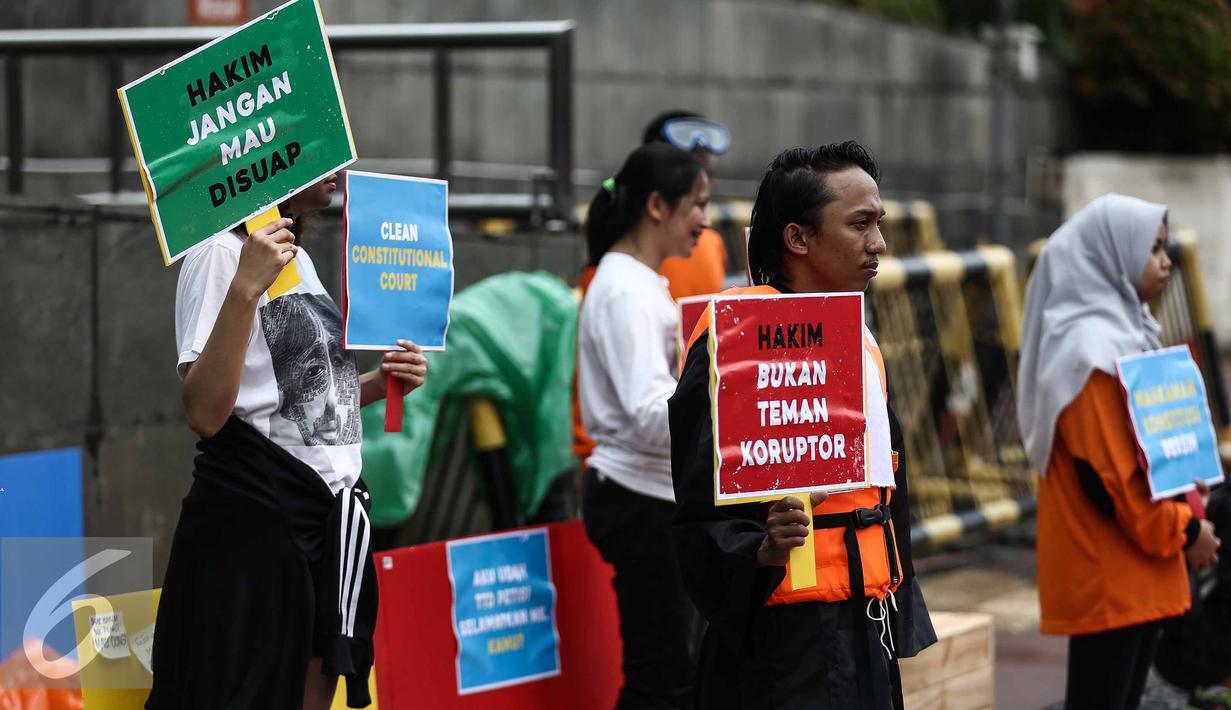 Aksi teatrikal Indonesia Corruption Watch (ICW) saat Car Free Day dikawasan Bunderan HI, Jakarta, Minggu (12/2). Menurut mereka aksi ini ditujukan atas keprihatinan terhadap Mahkamah Konstitusi. (Liputan6.com/Faizal Fanani)