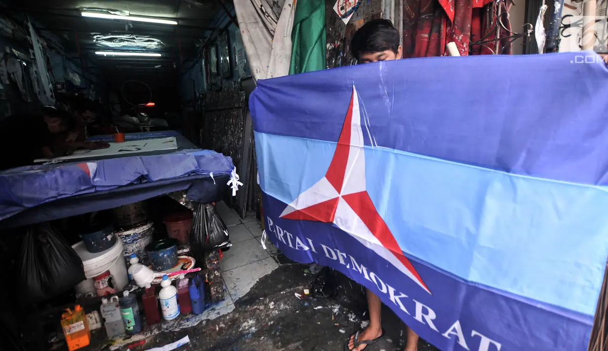 Pekerja menunjukkan bendera salah satu partai politik yang telah selesai dibuat di Percetakan Andalas Jaya, Jakarta, Rabu (2/1). Pedagang mengaku pemesanan naik hingga 60 persen dari bulan biasa. (Merdeka.com/Iqbal Nugroho)