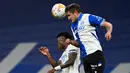 Bek Deportivo Alaves Nahuel Tenaglia berebut bola dengan penyerang Real Madrid Vinicius Junior pada pekan ke-25 La Liga Spanyol di Santiago Bernabeu, Minggu (20/2/2022) dinihari WIB. Real Madrid menang meyakinkan dengan skor 3-0. (OSCAR DEL POZO / AFP)