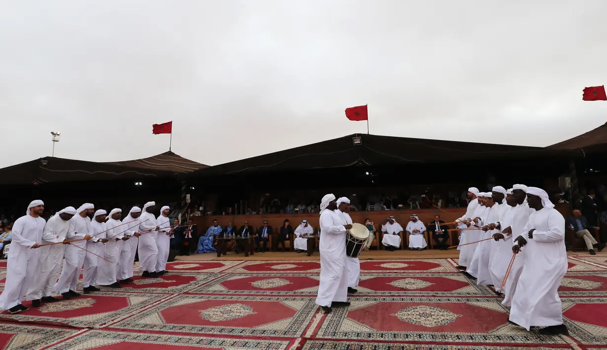 Para peserta bernyanyi dan menari saat Festival Tan-Tan Moussem Berber ke-14 di Kota Tan-Tan, Maroko, Minggu (8/7). Festival ini pertama kali digelar pada tahun 1963. (KARIM SAHIB/AFP)