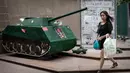 Seorang wanita berjalan melewati replika tank yang ditampilkan di Hong Kong untuk mengenang peristiwa berdarah di Lapangan Tiananmen, Tiongkok, pada 1989 silam, (3/6/2014). (AFP PHOTO/Philippe Lopez)