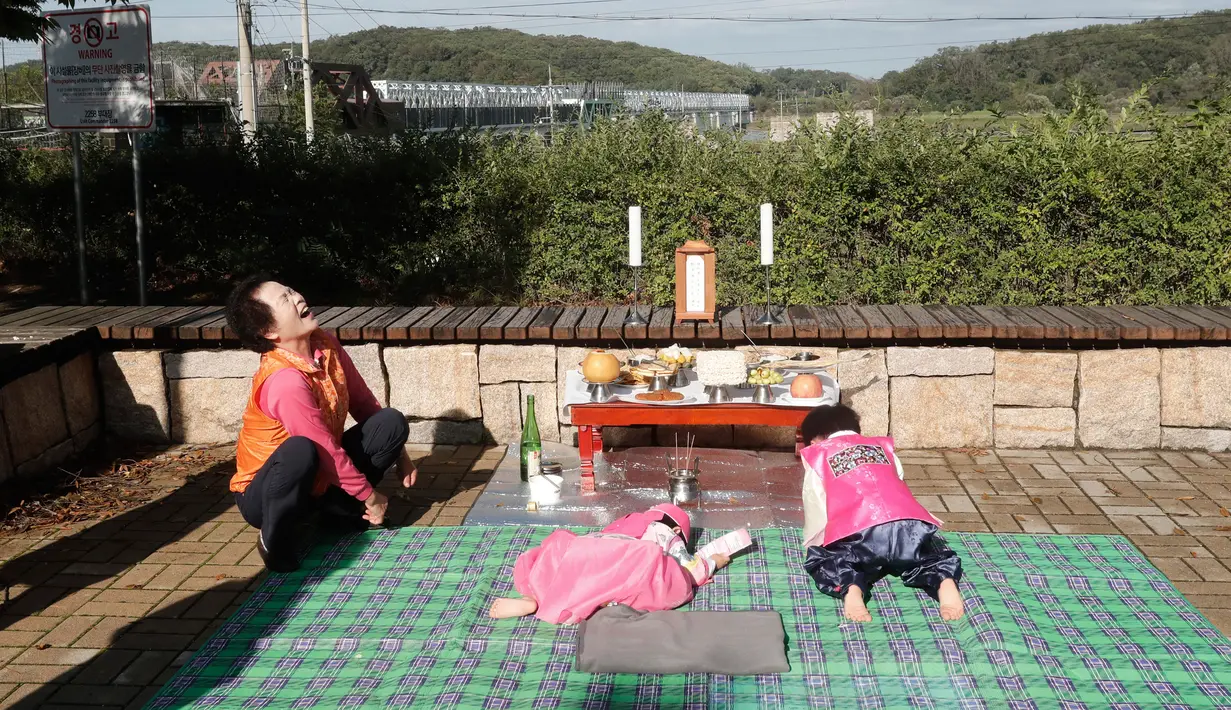 Anak-anak Korea Selatan, Oh Ryul dan Oh Hyun memberikan penghormatan kepada leluhur mereka untuk merayakan Chuseok di Imjingak Pavilion, Paju dekat perbatasan dengan Korea Utara, Jumat (13/9/2019). Chuseok sendiri merupakan Hari Thanksgiving di Korea. (AP/Ahn Young-joon)