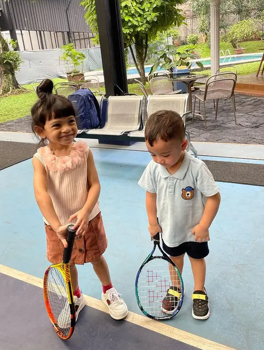 Atasan tersebut dipadukan rok mini coklat sertaSepatu putih dari Gucci dengan kaos kaki merahnya. Rayyanza pin terlihat mengenakan sepatu hitamnya. [@riniperdiyanti]