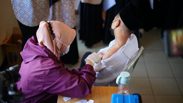Nampak sejumlah santri di pesantren Al-Masduqiyah tengah melaksanakan vaksinasi di lingkungan pesantren di Garut, Jawa Barat.
