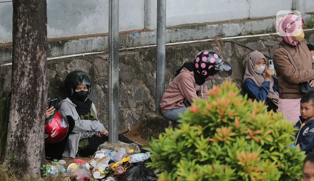 <p>Sejumlah pemudik yang menggunakan sepedah motor beristirahat di pelabuhan Merak, Banten, Sabtu (30/4/2022). Pemudik memanfaatkan kemacetan panjang untuk beristirahat sebelum menyebrang dengan kapal roro. (Liputan6.com/Angga Yuniar)</p>