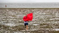 Wisatawan berjalan di perairan Teluk Tampa yang surut karena air surut dan angin kencang dari Badai Ian di Tampa, Florida, Amerika Serikat, 28 September 2022. (Willie J. Allen Jr./Orlando Sentinel via AP)